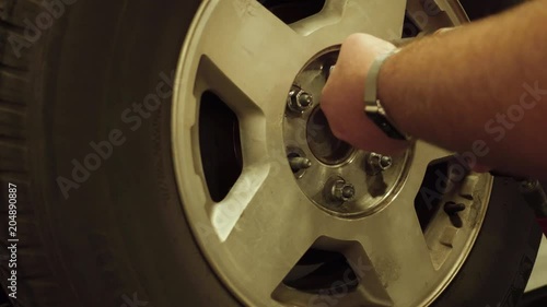 Technician Removing Lug Nuts From Wheel on a Vehicle