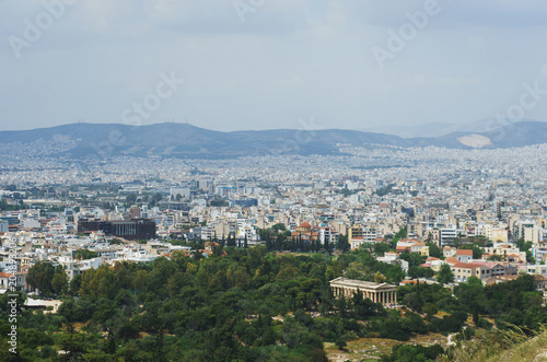 View from above on the streets and roofs of the houses of a modern European city. Athens summer day from a height. © Evgenii Starkov