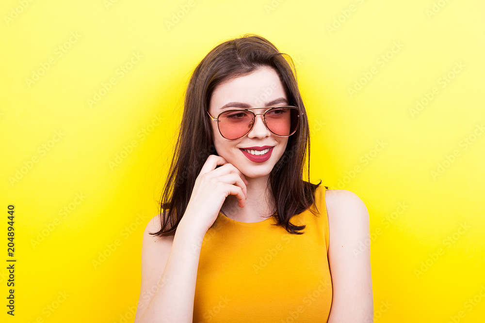 Sexy woman wearing sunglasses on yellow background Sexy woman wearing sunglasses on yellow background