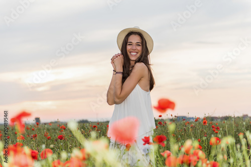 Fototapeta Naklejka Na Ścianę i Meble -  Happy woman in the field of red poppies