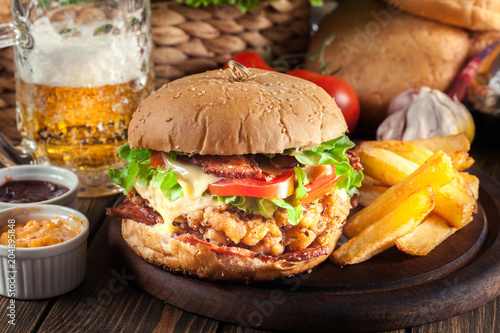 Delicious burger with chicken  bacon  tomato and cheese