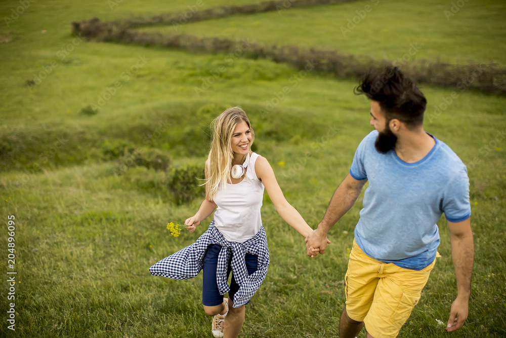 Couple enjoying a walk through grass land Couple enjoying a walk through grass land