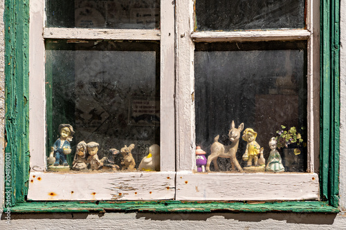 Fotografija Collection of statuettes inside old wooden window.