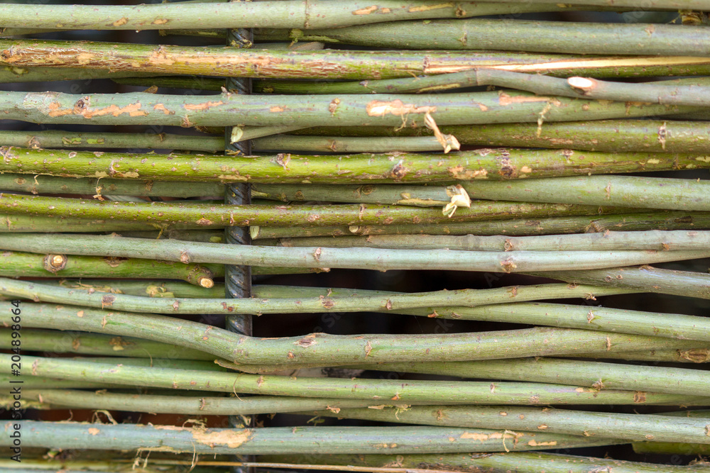wall of willow twigs as background. Rural old fence, made from willow tree twigs and branches. wall of willow twigs as background. Rural old fence, made from willow tree twigs and branches.