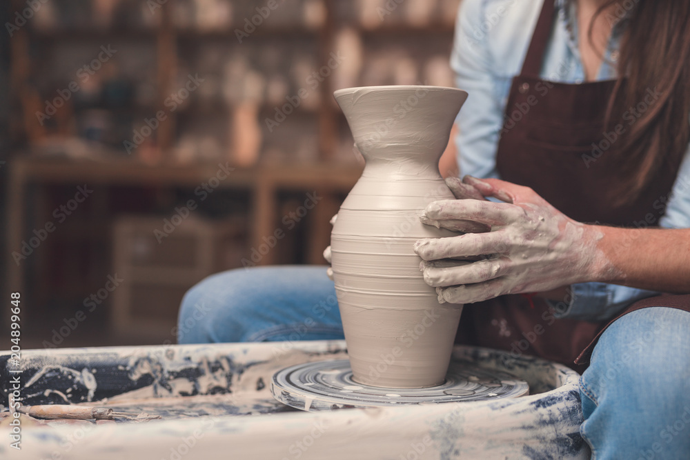 Young couple working on a potter's wheel Young couple working on a potter's wheel