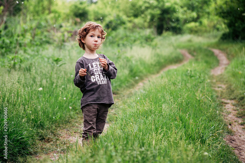 Obraz na plátne Adorable little toddler boy staying near the tree
