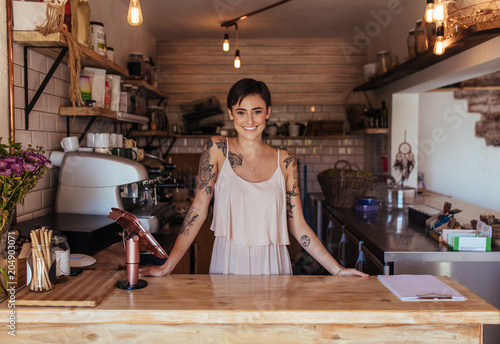Woman entrepreneur standing at the billing counter of her cafe photo