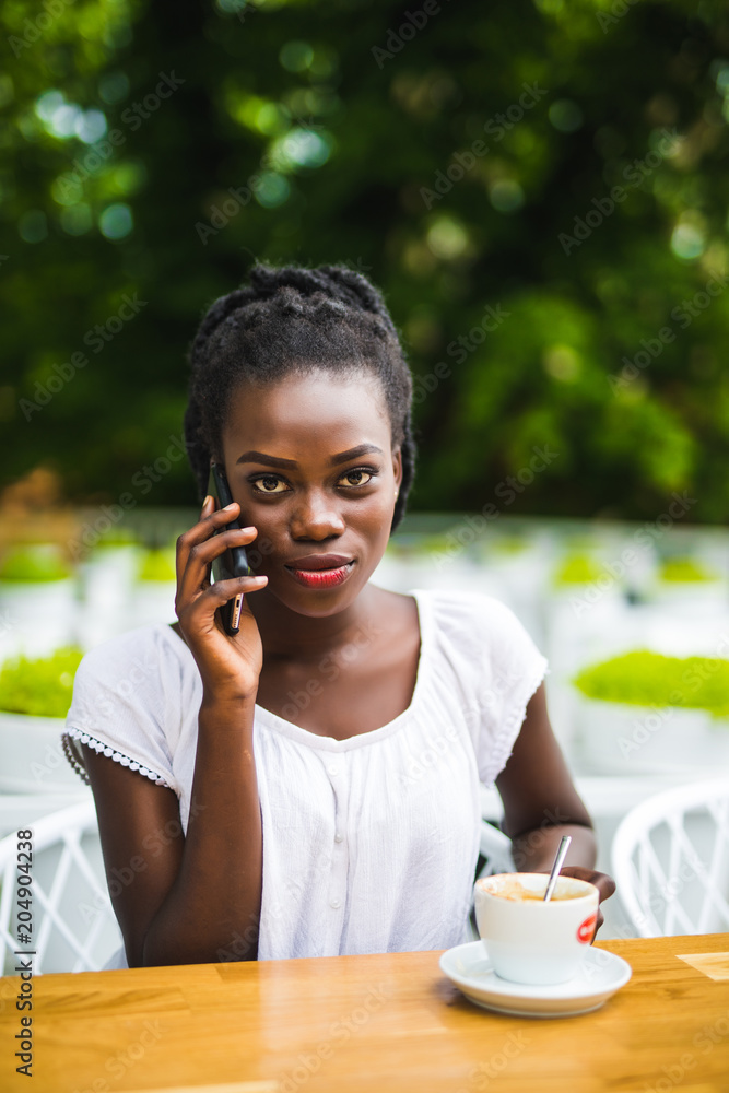 Portrait of young woman talking on phone with coffee outside Portrait of young woman talking on phone with coffee outside