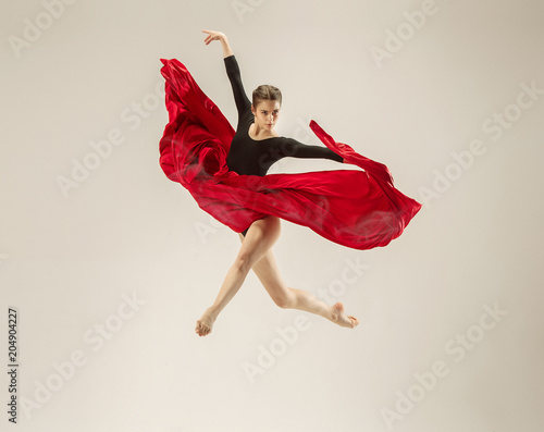 Modern ballet dancer dancing in full body on white studio background.