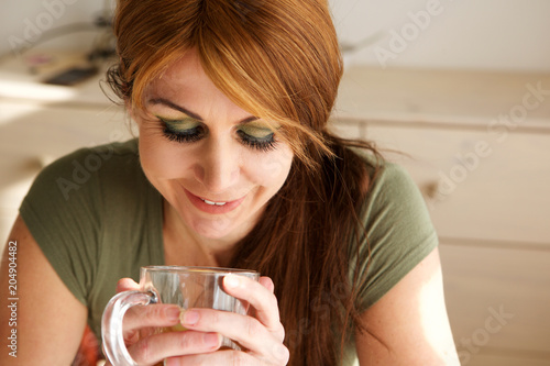 Happy mature woman having green tea