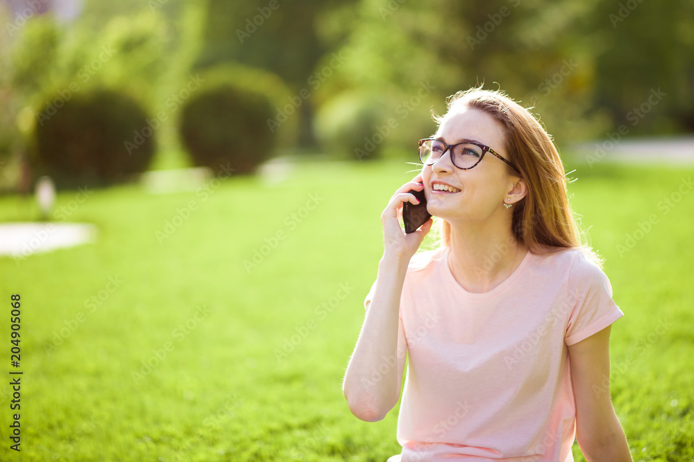 girl with glasses talking on the phone outdoors. copy space. girl with glasses talking on the phone outdoors. copy space.