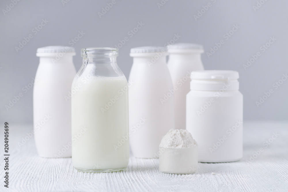 milk in a glass jar, milk powder and drink yogurt on the table, gray background milk in a glass jar, milk powder and drink yogurt on the table, gray background