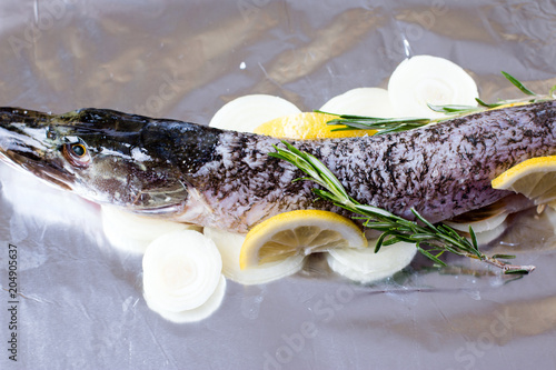 Fresh fish with lemon, lime, rosemary, salt and pepper photo