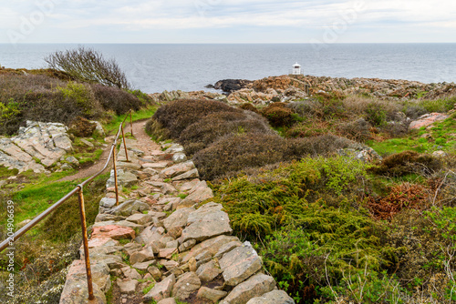 Western Kullaberg nature reserve, Sweden - The small white lighthouse Kullen west at the end of a coastal cliff by the sea.