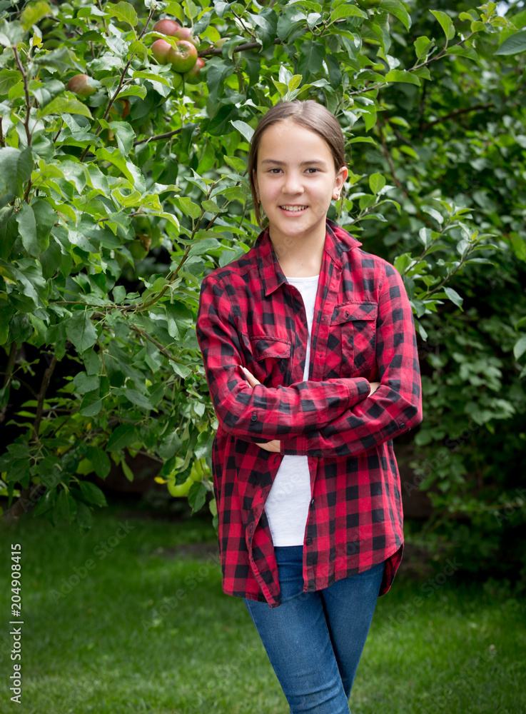 Portrait of smiling brunette teenage girl in apple orchard Portrait of smiling brunette teenage girl in apple orchard