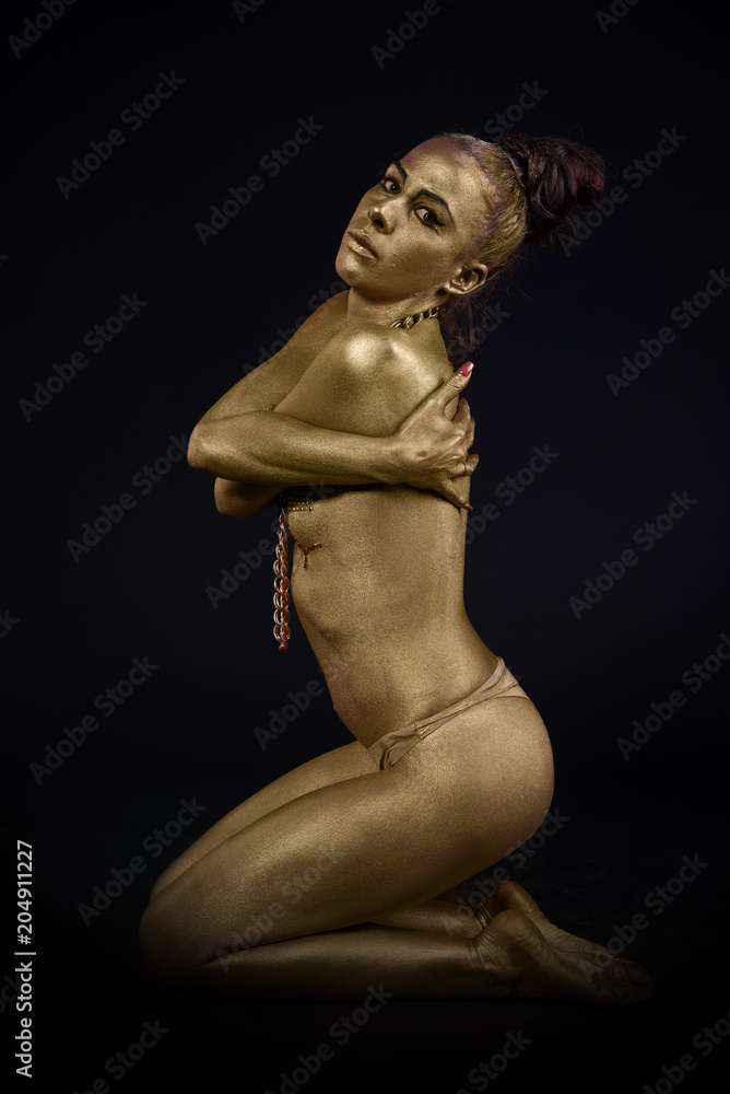 woman fully dressed in gold on black background woman fully dressed in gold on black background