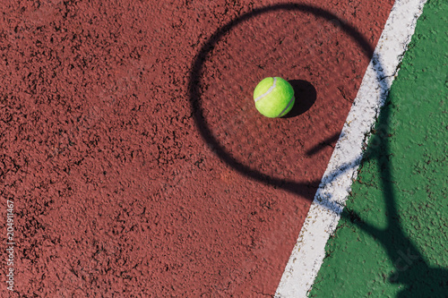 Tennis racket shadow and ball on tennis court © Tom Eversley