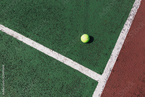 Yellow tennis ball on green tennis court © Tom Eversley
