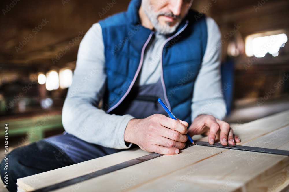 A man worker in the carpentry workshop, working with wood. A man worker in the carpentry workshop, working with wood.