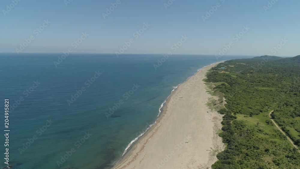 Aerial view of coastline with sandy beautiful beach. Philippines, Luzon. Ocean coastline with turquoise water. Philippines, Luzon. Tropical landscape in Asia.