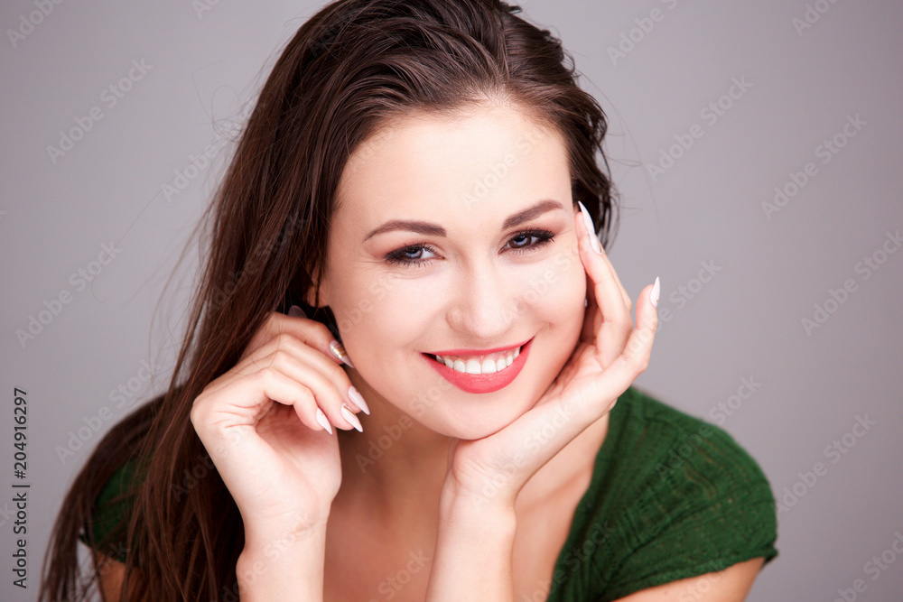 Close up attractive young woman smiling with hand on face Close up attractive young woman smiling with hand on face
