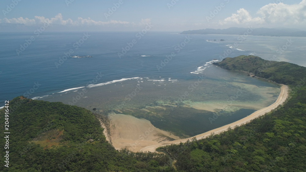 Aerial view of wild beaches. Coast of a tropical island Palau with mountains covered with rainforest and trees. Santa Ana, Philippines. Aerial view of island with wild beaches.