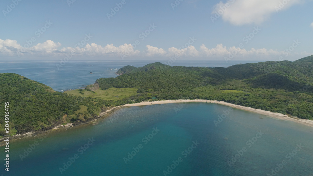 Aerial view of tropical beach. Coast of a tropical island Palau with mountains covered rainforest. Cape Engano, province of Cagayan, Philippines. Aerial view of tropical beach. Coast of a tropical island Palau with mountains covered rainforest. Cape Engano, province of Cagayan, Philippines.