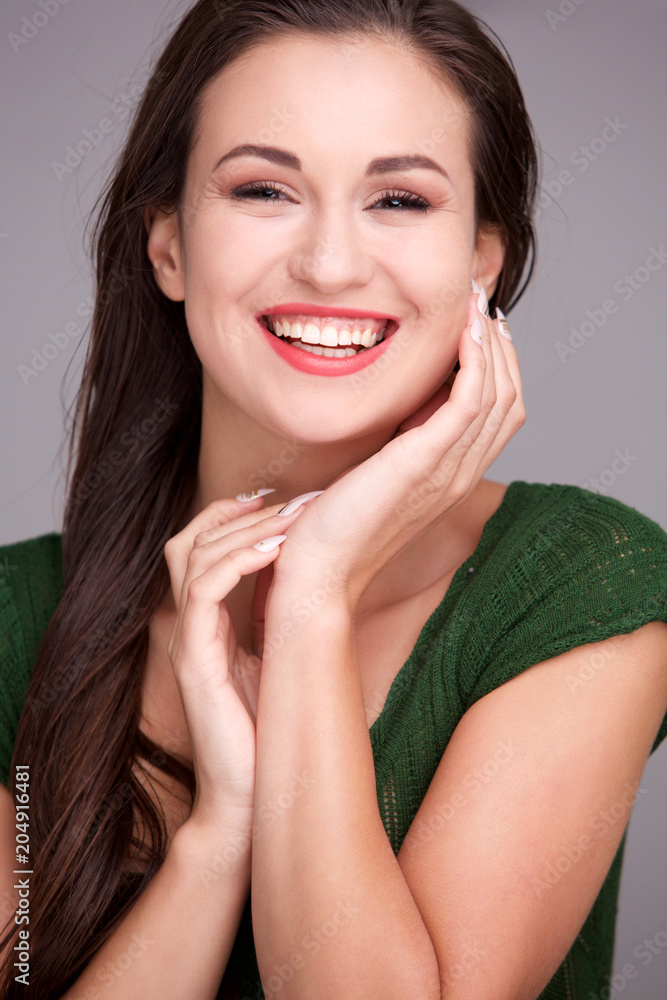 Close up beautiful young woman laughing against gray background Close up beautiful young woman laughing against gray background