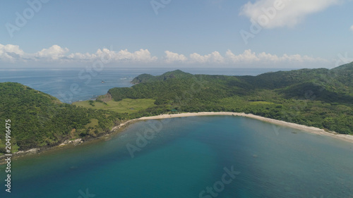Aerial view of tropical beach. Coast of a tropical island Palau with mountains covered rainforest. Cape Engano, province of Cagayan, Philippines.