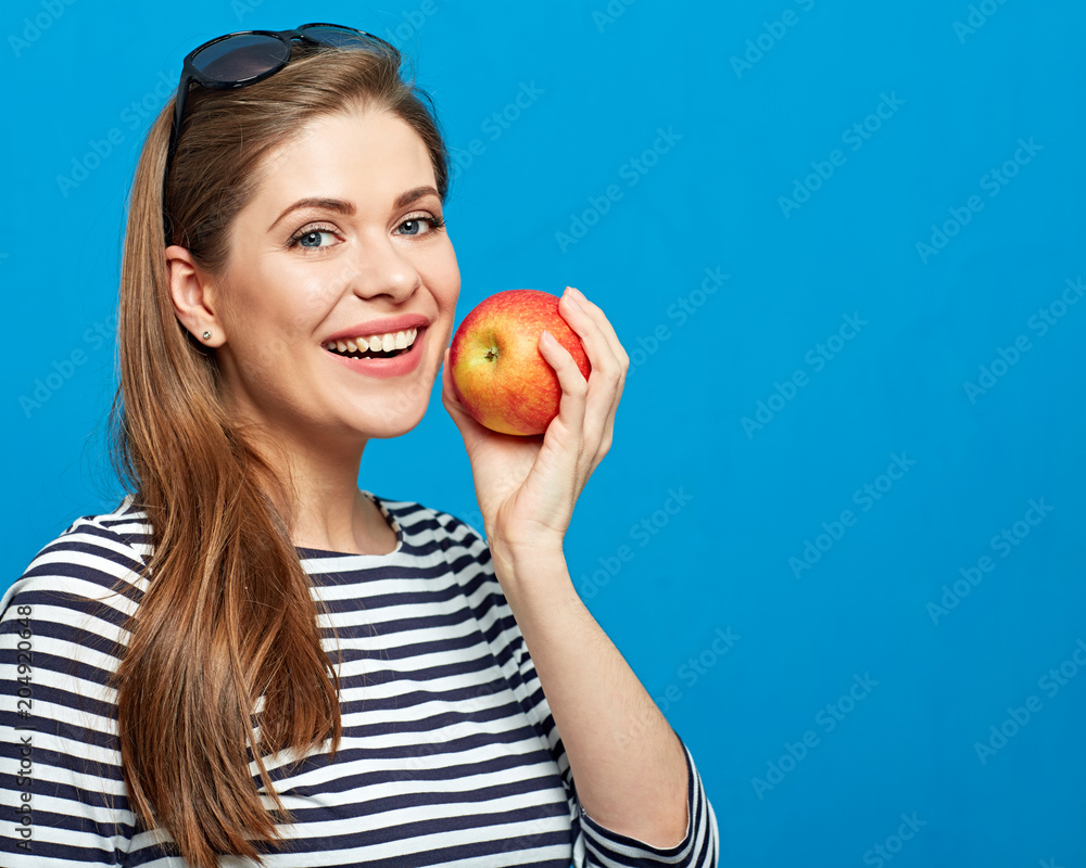 Portrait of woman with healthy teeth biting red apple