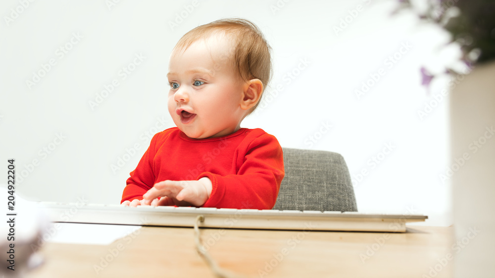 Happy child baby girl toddler sitting with keyboard of computer isolated on a white background Happy child baby girl toddler sitting with keyboard of computer isolated on a white background