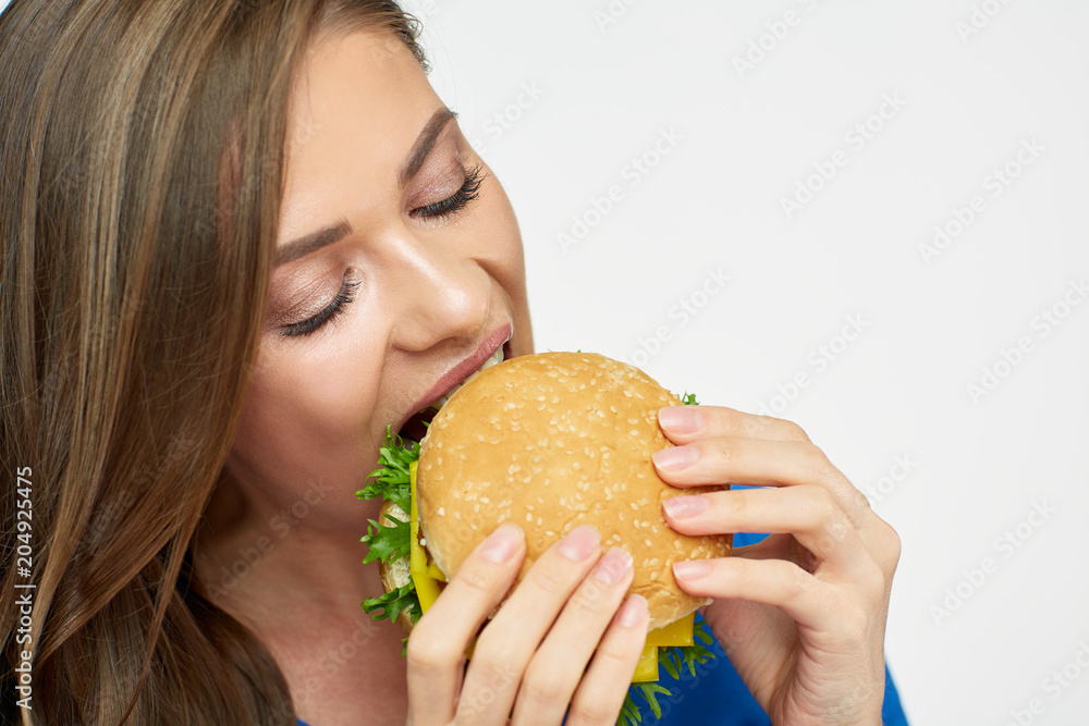 Close up portrait of woman eating burger.