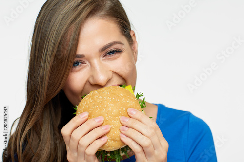 Smiling woman eating fast food burger.