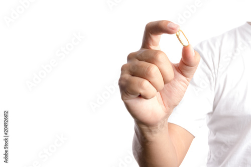 Hand holding nutrition capsule contain vitamin or fish oil pill