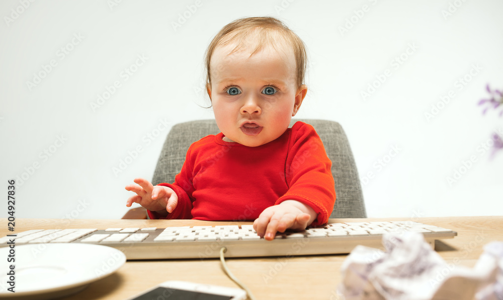 Happy child baby girl toddler sitting with keyboard of computer isolated on a white background Happy child baby girl toddler sitting with keyboard of computer isolated on a white background