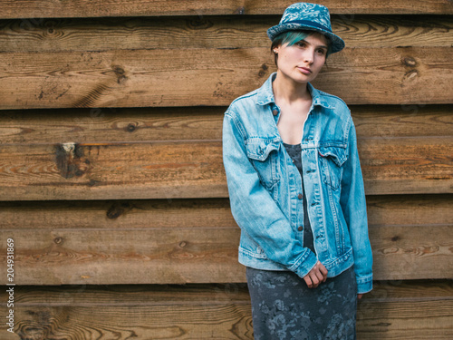 A young woman in jeans near wood wall photo