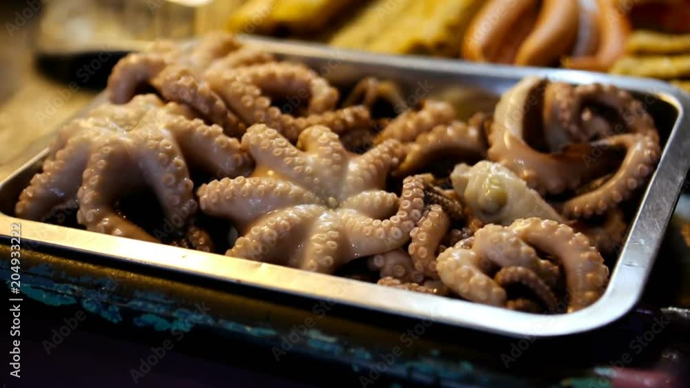 Boiled Octopus. People cooking, selling and buying Asian street Food. Boiled Octopus. People cooking, selling and buying Asian street Food.