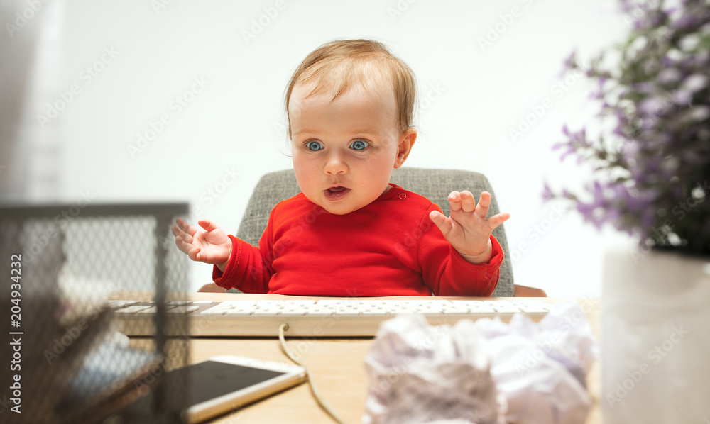 Happy child baby girl toddler sitting with keyboard of computer isolated on a white background Happy child baby girl toddler sitting with keyboard of computer isolated on a white background