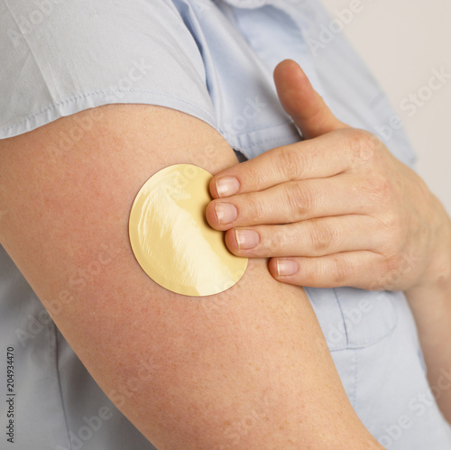 Wallpaper Mural YOUNG WOMAN APPLYING FLESH COLOURED NICOTINE PATCH TO ARM Torontodigital.ca