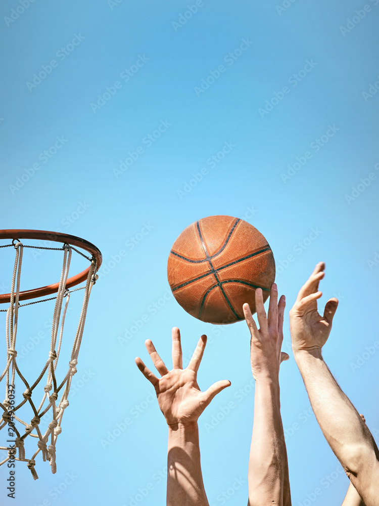 Two basketball players throw the ball into the basket with both hands.