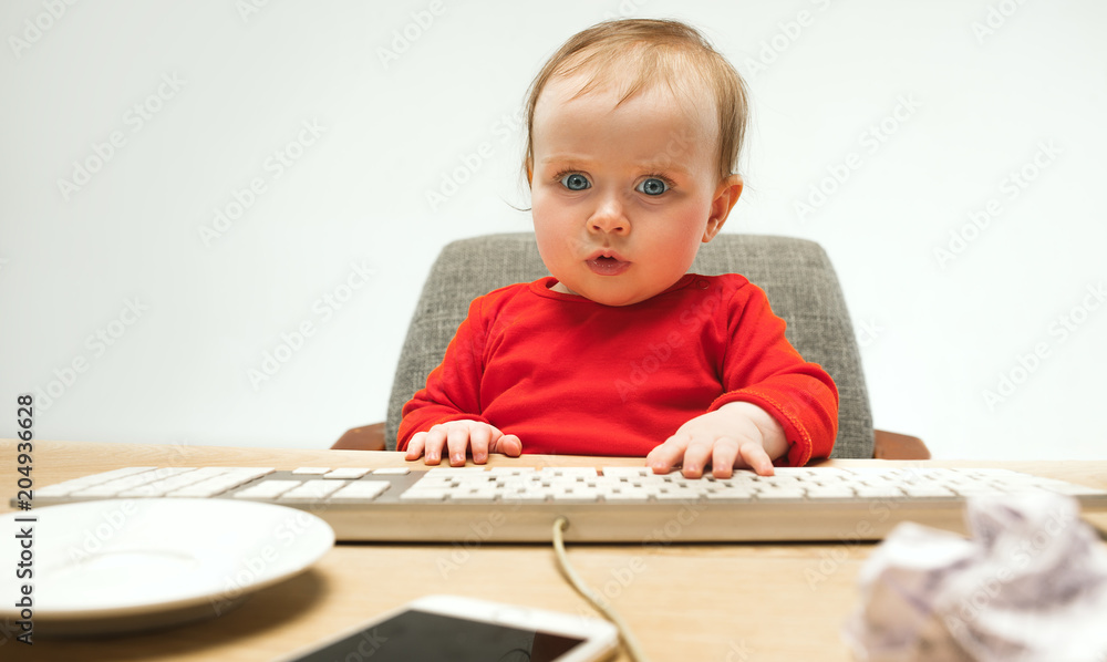 Happy child baby girl toddler sitting with keyboard of computer isolated on a white background Happy child baby girl toddler sitting with keyboard of computer isolated on a white background