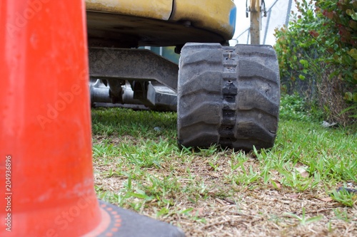 ground view of mini excavator track behind traffic cone photo