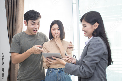 Young Couple Who are looking for Purchasing/ Renting New Home. Professional Real Estate Agent talking to Customer for Contracts.