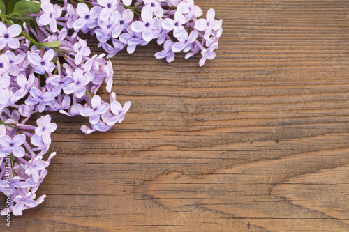 Fresh flowers frame of purple Lilac flowers on wooden background