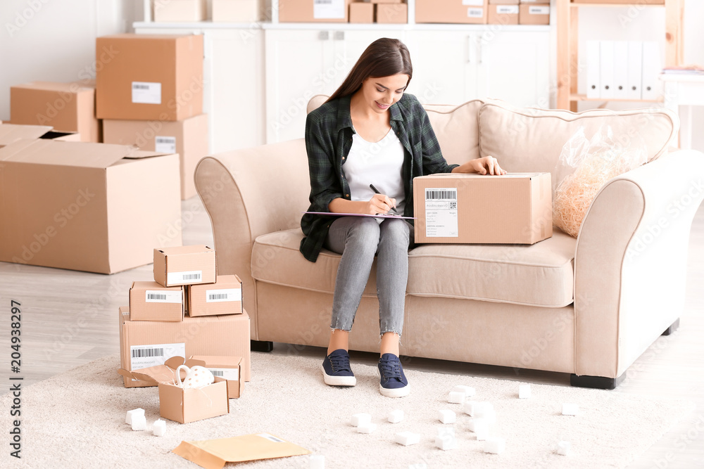 Young woman preparing parcel for shipment to client at home Young woman preparing parcel for shipment to client at home