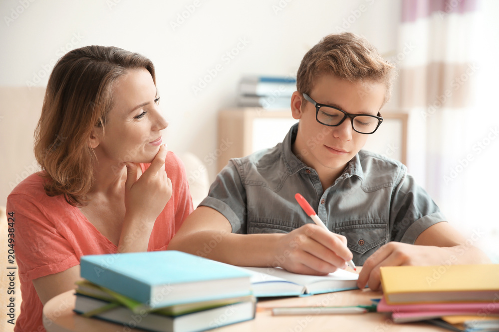 Teenager with mother doing homework at home Teenager with mother doing homework at home