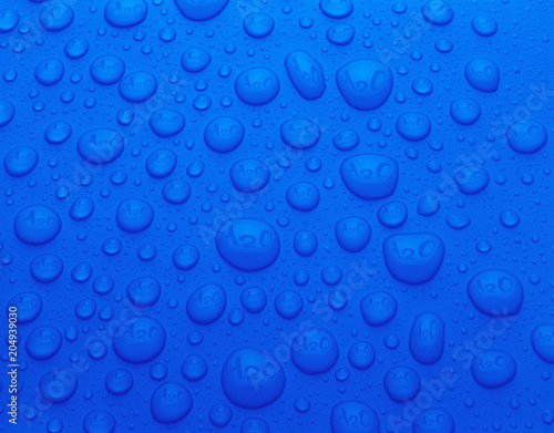 BLUE WATER DROPS ON BLUE BACKGROUND REFLECTING THE CHEMICAL SYMBOL H20