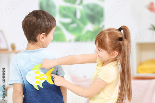 Little girl sticking paper ...