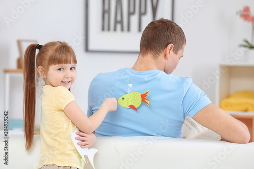 Little girl sticking paper ...