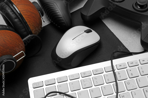 Modern mouse, headphones and keyboard on table